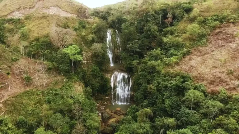 Aerial view of Hiru Manu Waterfall dropping through a forested ravine in Sumba