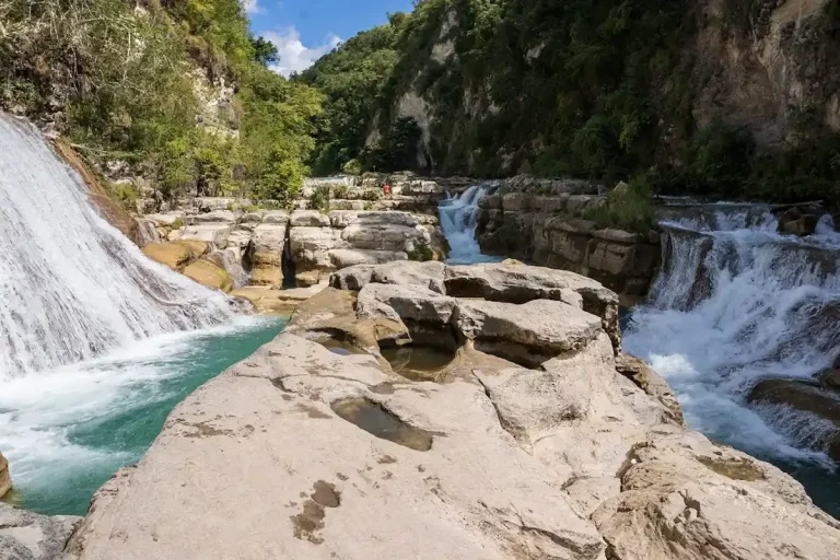 Water flowing through a carved limestone canyon on a waterfall trek in Sumba