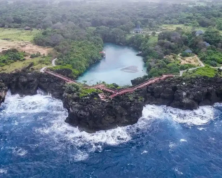Drone view of Weekuri Lagoon separated from the surf by a rocky reef in Southwest Sumba
